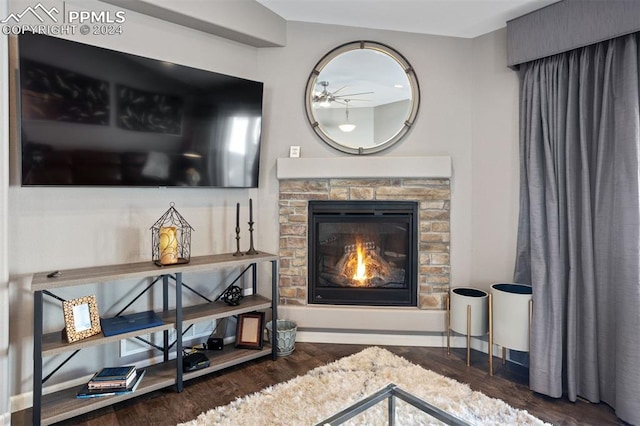 living room featuring ceiling fan, a fireplace, and dark hardwood / wood-style floors