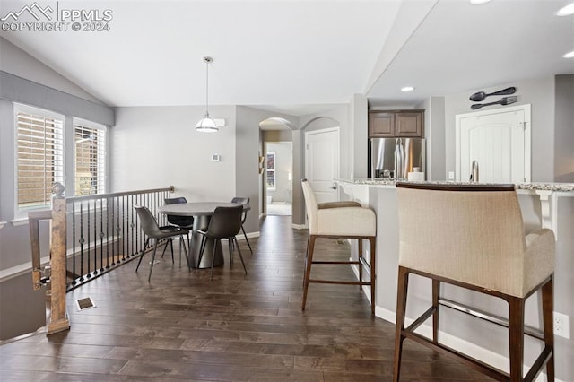 dining area with lofted ceiling and dark wood-type flooring