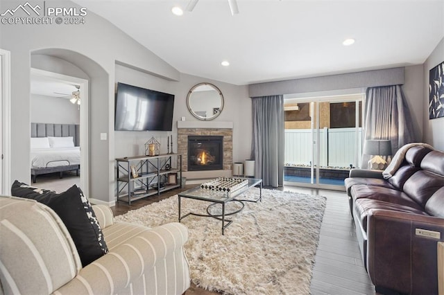 living room with a fireplace, ceiling fan, hardwood / wood-style floors, and vaulted ceiling