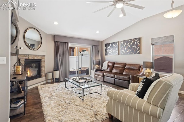 living room featuring ceiling fan, a stone fireplace, dark wood-type flooring, and vaulted ceiling