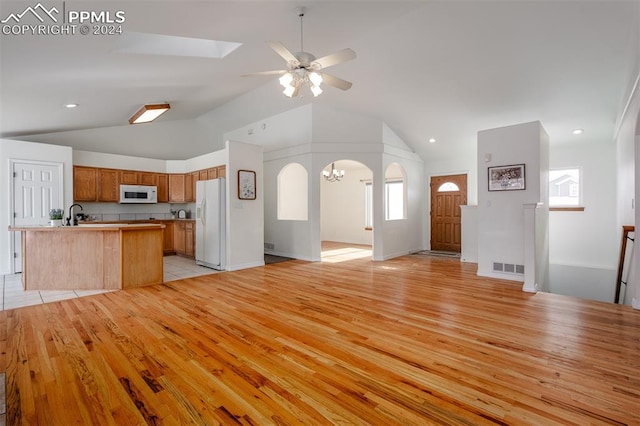 kitchen with light wood-type flooring, lofted ceiling, ceiling fan, and white appliances