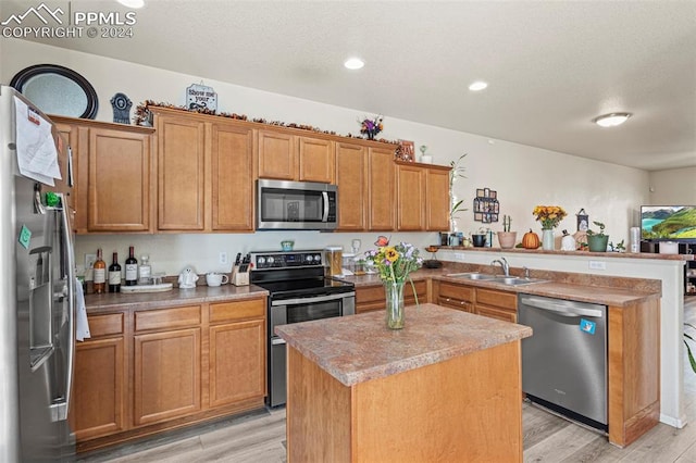 kitchen featuring light hardwood / wood-style floors, a center island, stainless steel appliances, and sink