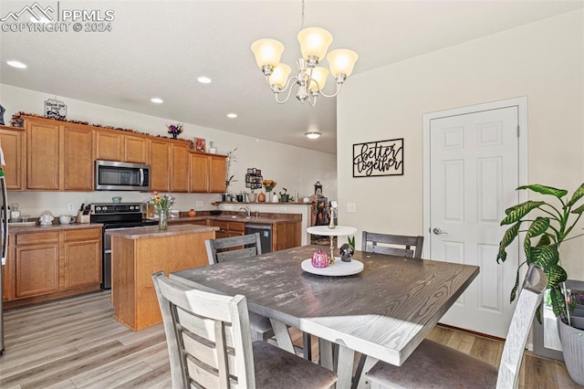 dining space featuring light hardwood / wood-style flooring, an inviting chandelier, and sink