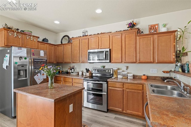 kitchen featuring light hardwood / wood-style floors, stainless steel appliances, sink, and a kitchen island