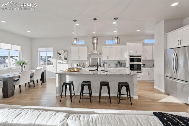 kitchen with stainless steel appliances, a center island with sink, and white cabinets