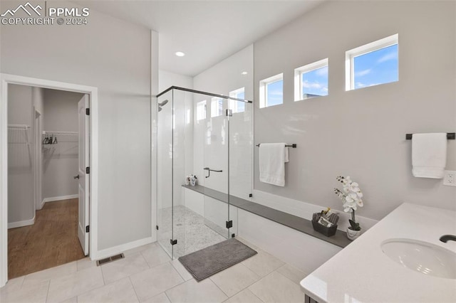 bathroom featuring tile patterned flooring, an enclosed shower, and sink