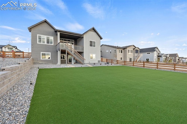 back of house with a lawn and a wooden deck