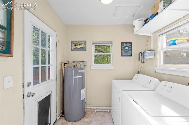 washroom featuring plenty of natural light, water heater, light tile patterned flooring, and washing machine and clothes dryer