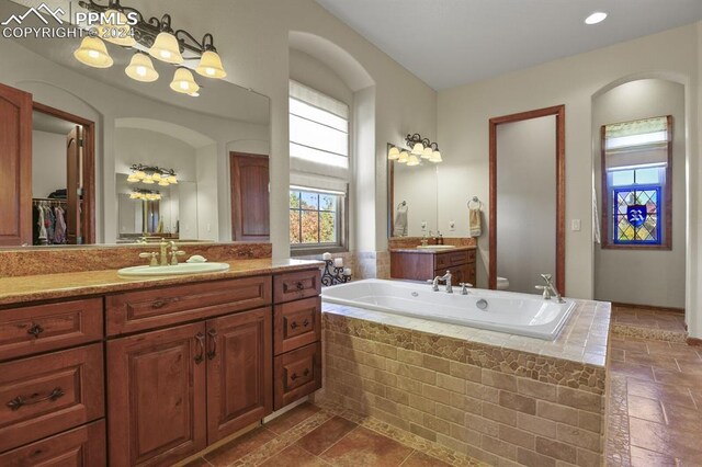 bathroom with vanity and a relaxing tiled tub