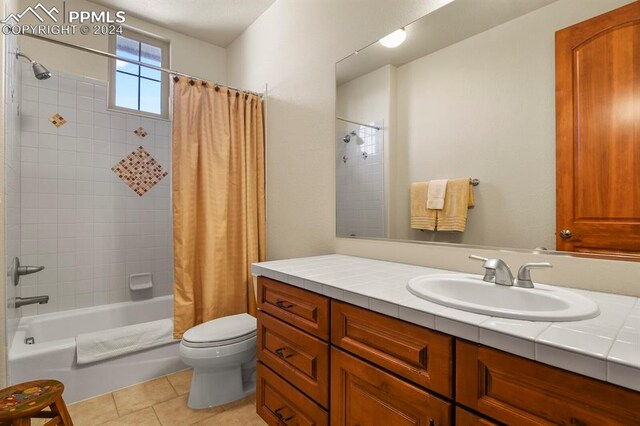 full bathroom with vanity, shower / tub combo with curtain, toilet, and tile patterned flooring