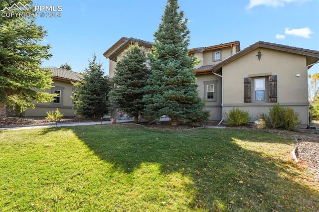view of front facade with a front lawn and stucco siding