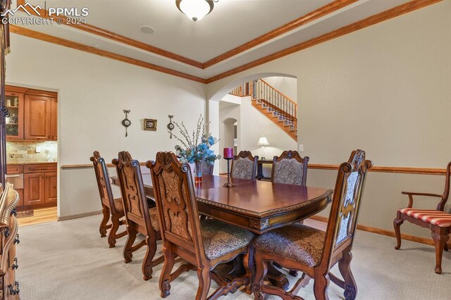 carpeted dining area with ornamental molding