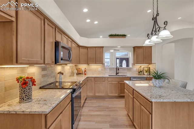 kitchen featuring light hardwood / wood-style flooring, stainless steel appliances, sink, vaulted ceiling, and decorative light fixtures