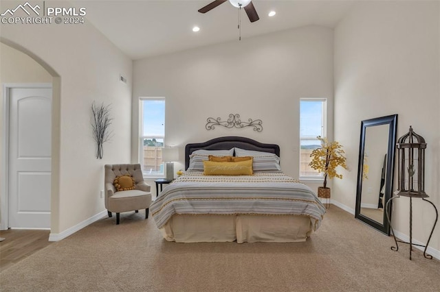 carpeted bedroom featuring ceiling fan and high vaulted ceiling