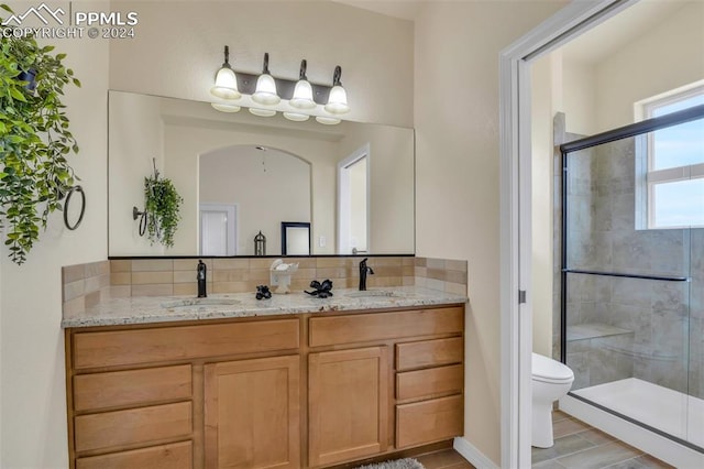 bathroom featuring vanity, toilet, and an enclosed shower