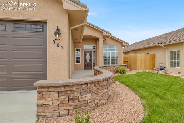 property entrance with a yard and a garage