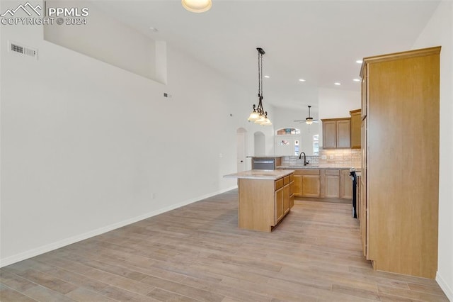 kitchen with hanging light fixtures, sink, a center island, light hardwood / wood-style floors, and ceiling fan