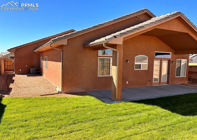 back of house featuring a patio area, central AC unit, and a lawn