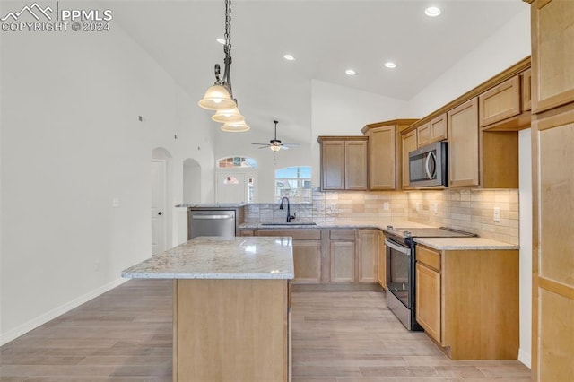 kitchen featuring appliances with stainless steel finishes, sink, light hardwood / wood-style floors, and a kitchen island