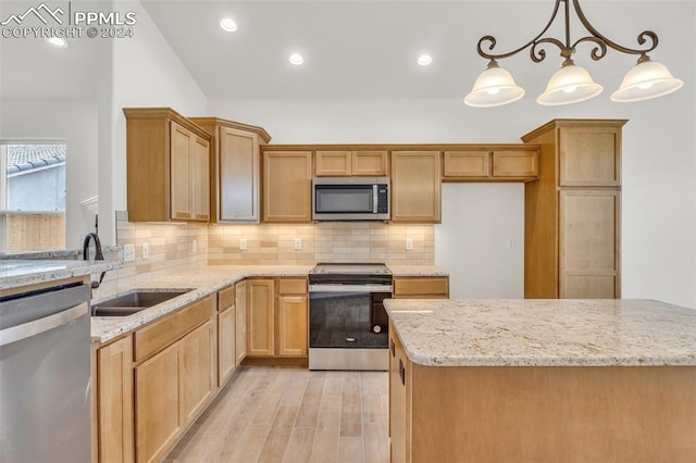 kitchen with tasteful backsplash, appliances with stainless steel finishes, light hardwood / wood-style flooring, pendant lighting, and sink