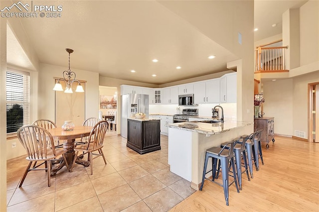 kitchen featuring white cabinetry, light wood-type flooring, stainless steel appliances, and kitchen peninsula