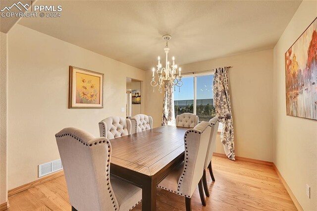 dining room featuring light hardwood / wood-style flooring and an inviting chandelier