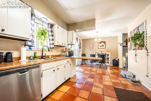 kitchen featuring white cabinets, stainless steel dishwasher, light tile patterned flooring, pendant lighting, and sink