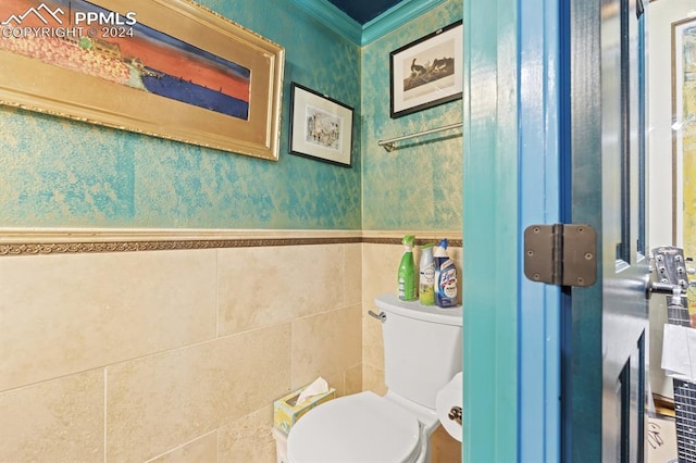 bathroom featuring toilet and tile walls