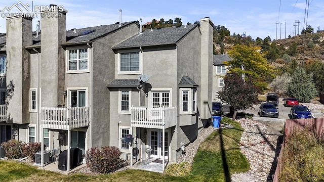 back of property with a patio area, a balcony, and central AC unit