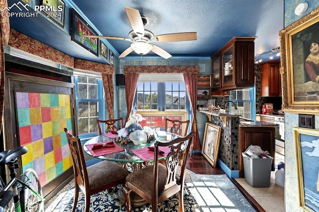 dining room featuring crown molding, a textured ceiling, light tile patterned floors, and ceiling fan