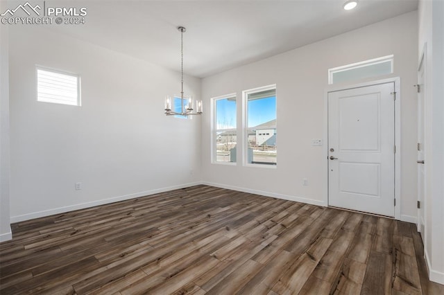 unfurnished dining area with a chandelier and dark wood-type flooring