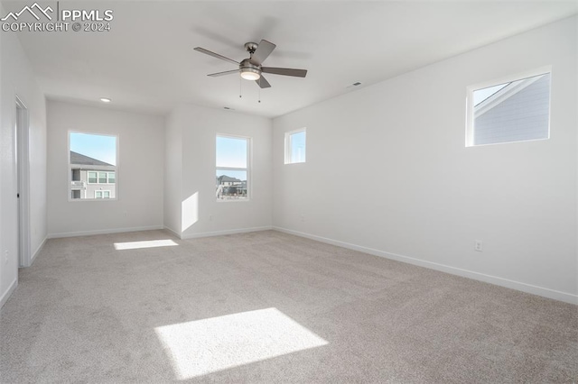 unfurnished room featuring ceiling fan and light colored carpet