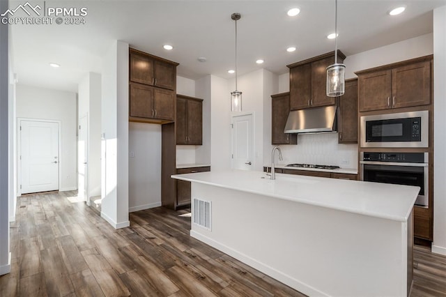 kitchen featuring an island with sink, hanging light fixtures, and appliances with stainless steel finishes