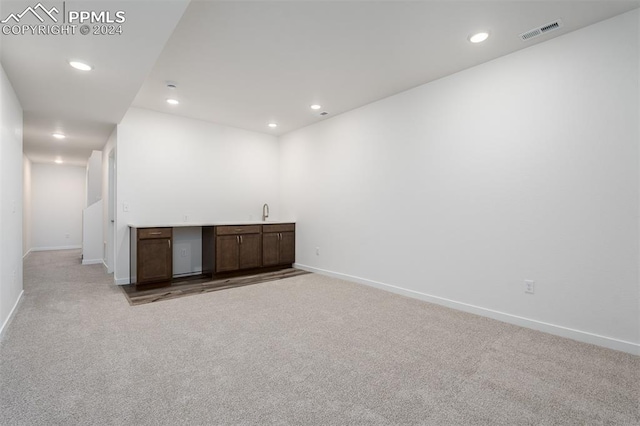 unfurnished room with light colored carpet and sink