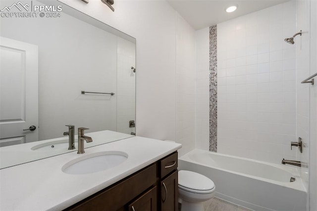 full bathroom with tiled shower / bath, vanity, and toilet