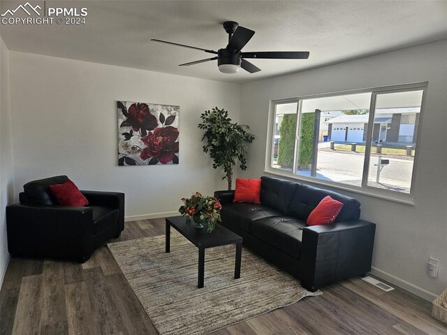 living room with dark wood-type flooring and ceiling fan