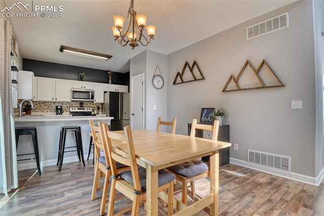 dining area with a chandelier and light wood-type flooring