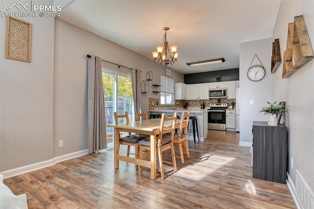 dining space with an inviting chandelier and light wood-type flooring