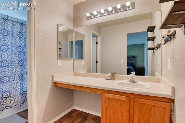 bathroom with vanity, hardwood / wood-style flooring, and walk in shower