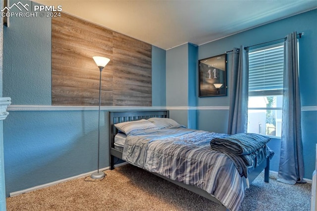 carpeted bedroom with wood walls