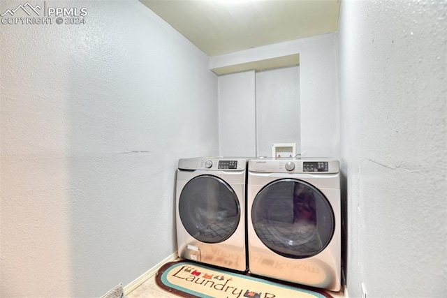 clothes washing area featuring washing machine and dryer and tile patterned flooring