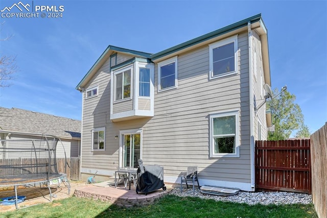 rear view of house featuring a patio and a trampoline