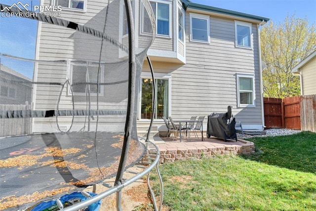 rear view of property featuring a patio area and a lawn