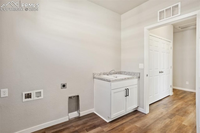 laundry area with hookup for an electric dryer, sink, hookup for a washing machine, and hardwood / wood-style flooring