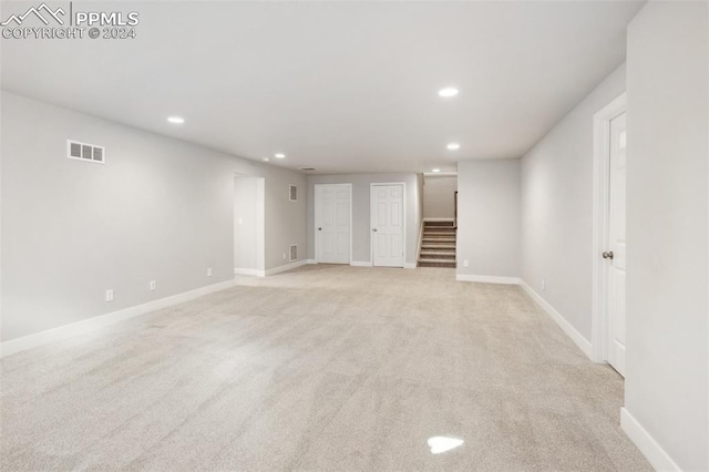 unfurnished room featuring light carpet