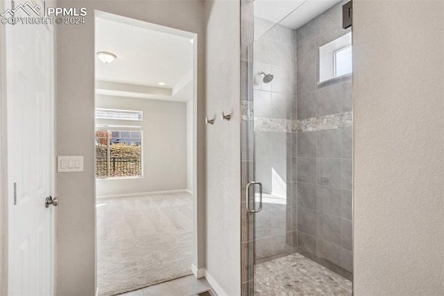 bathroom with a wealth of natural light, tile patterned floors, and walk in shower