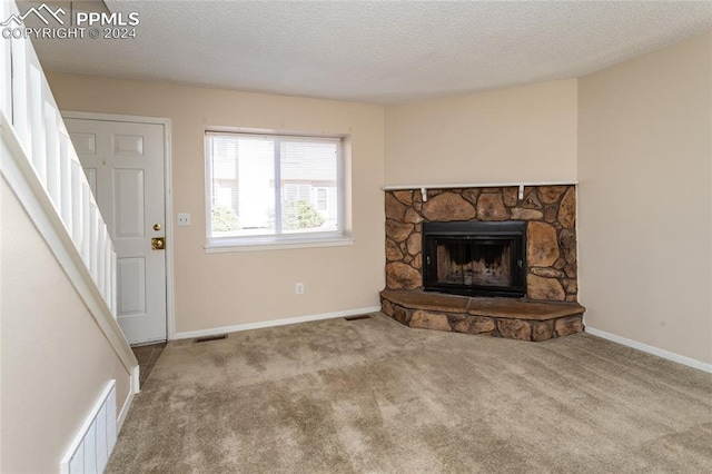 carpeted living room featuring a fireplace and a textured ceiling