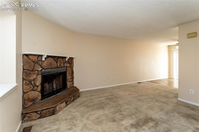 carpeted living room with a textured ceiling, a fireplace, and ceiling fan