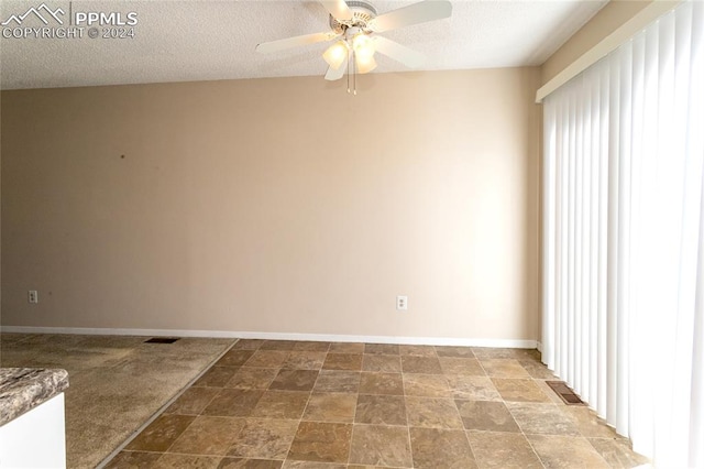 spare room with ceiling fan and a textured ceiling