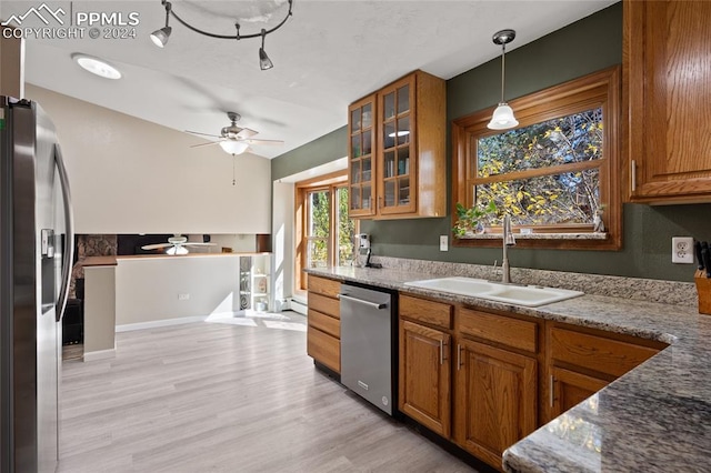 kitchen featuring sink, appliances with stainless steel finishes, decorative light fixtures, and stone countertops